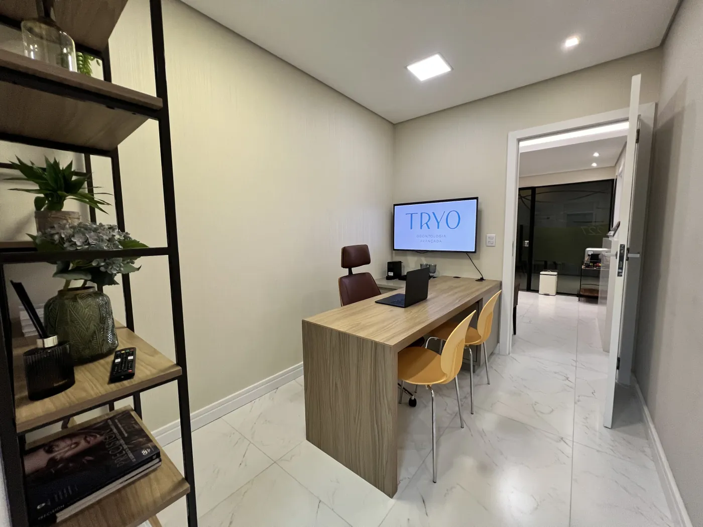 Sala de planejamento da Tryo, com a marca exibida na tela e poltronas para o paciente